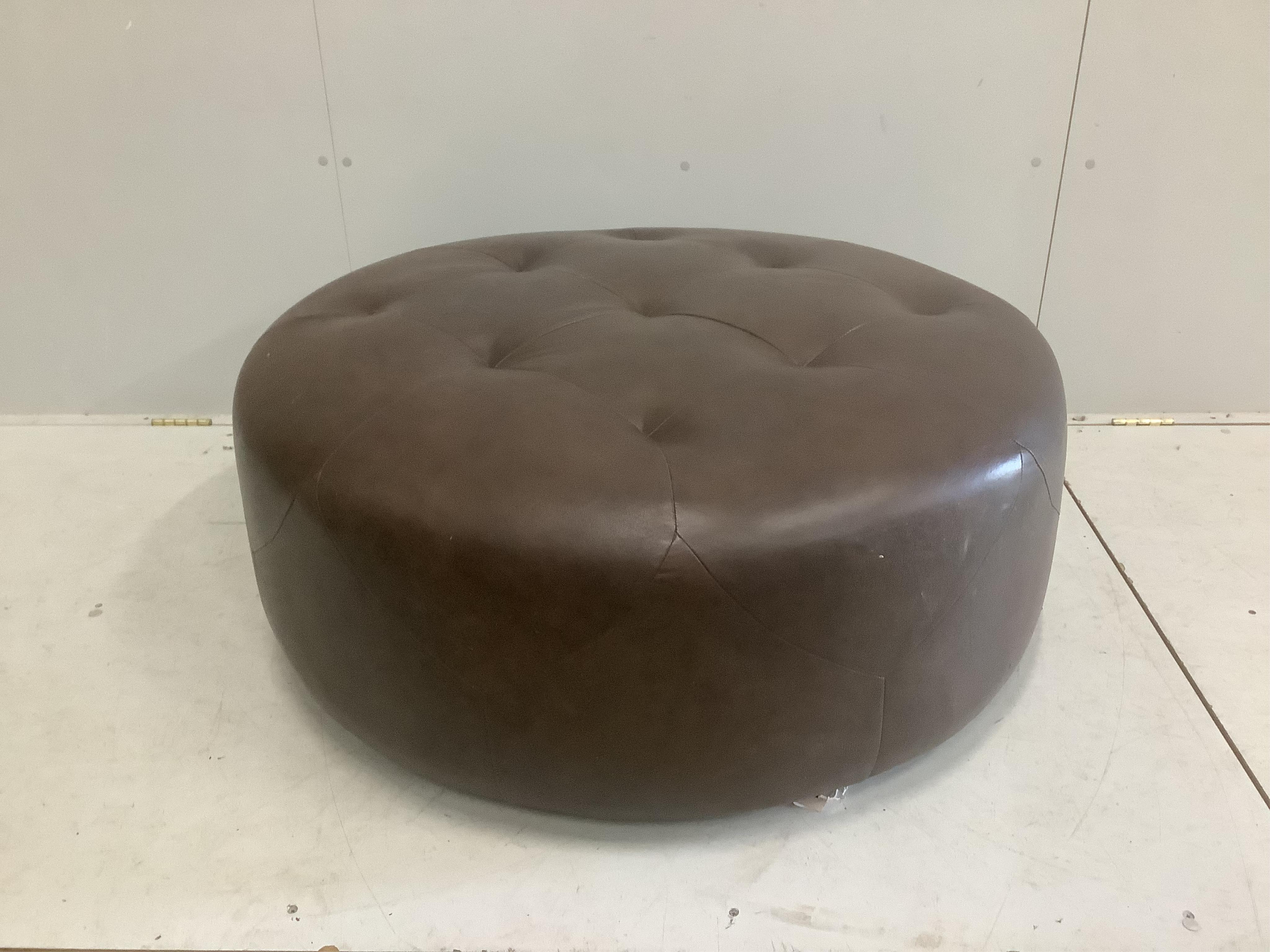 A circular brown leather footstool, diameter 100cm, height 36cm. Condition - good